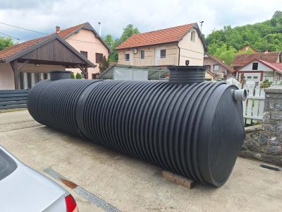 Detalj plastičnog horizontalnog rezervoara za vodu sa priključkom, postavljen u seoskom domaćinstvu u Srbiji