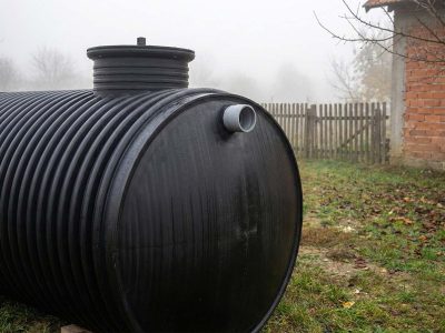 Detalj plastičnog horizontalnog rezervoara za vodu sa priključkom, postavljen u seoskom domaćinstvu u Srbiji
